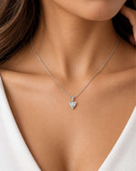 Close-up of a South Sudanese female model wearing a delicate yellow gold necklace featuring a 6mm heart-shaped moissanite pendant in a three-prong setting with a polished bail.