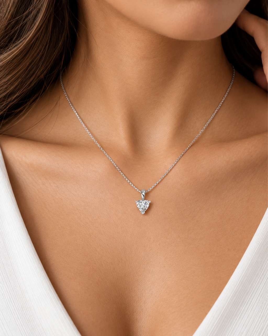 Close-up of a South Sudanese female model wearing a delicate yellow gold necklace featuring a 6mm heart-shaped moissanite pendant in a three-prong setting with a polished bail.