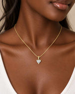 female model wearing a delicate yellow gold necklace with a 6mm heart-shaped moissanite pendant in a three-prong setting