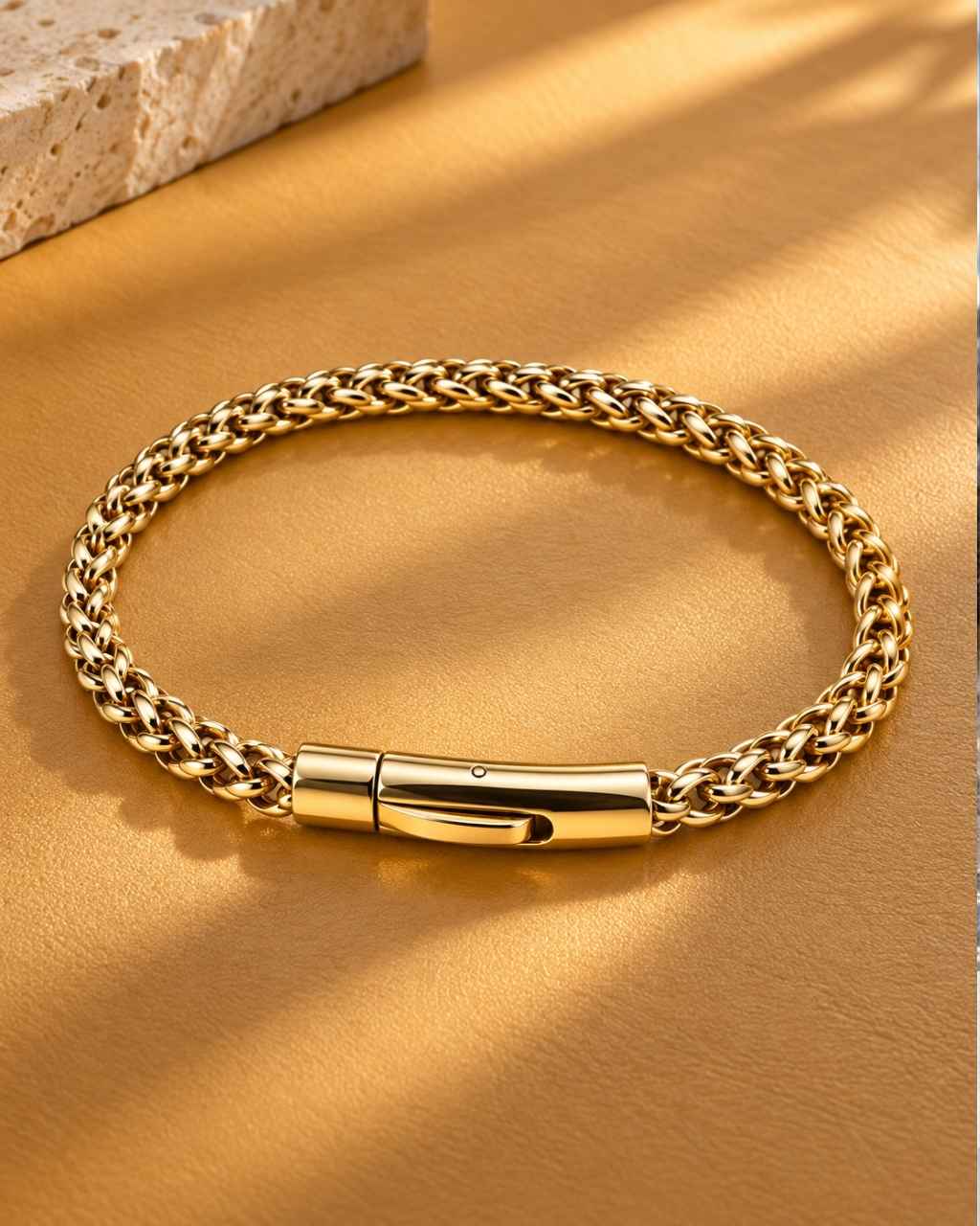 Men's stainless steel wheat link chain bracelet, 18K gold plated, styled on leather background